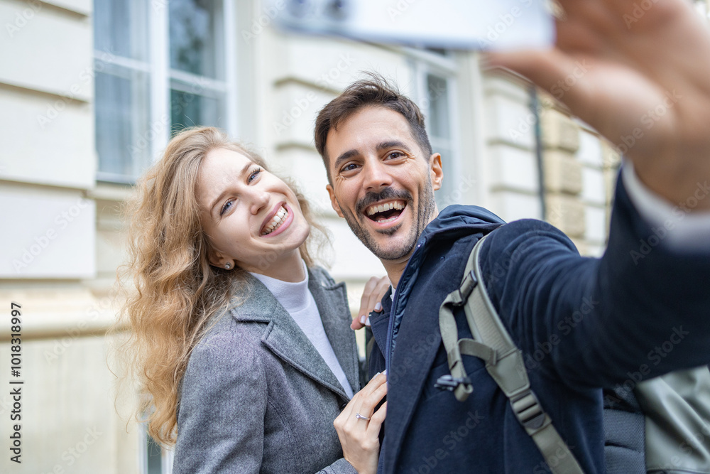 Handsome guy holding the phone in his hand and smiling and posing for a selfie with his girlfriend Handsome guy holding the phone in his hand and smiling and posing for a selfie with his girlfriend