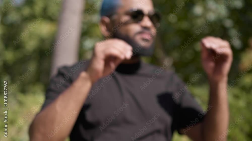 Blurred shot of a black man sunbathing suddenly looking at camera taking off his sunglasses and getting in focus.MOV