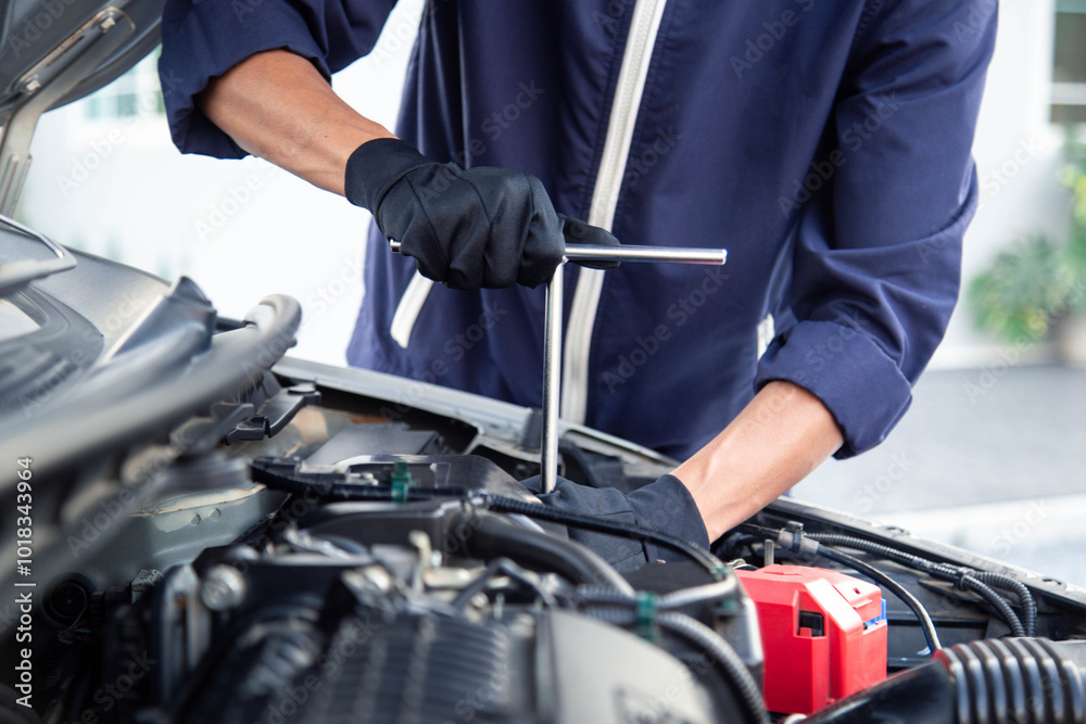 Professional mechanic working on the engine , repairing a car engine automotive workshop with a wrench, car service and maintenance,Repair service. Professional mechanic working on the engine , repairing a car engine automotive workshop with a wrench, car service and maintenance,Repair service.
