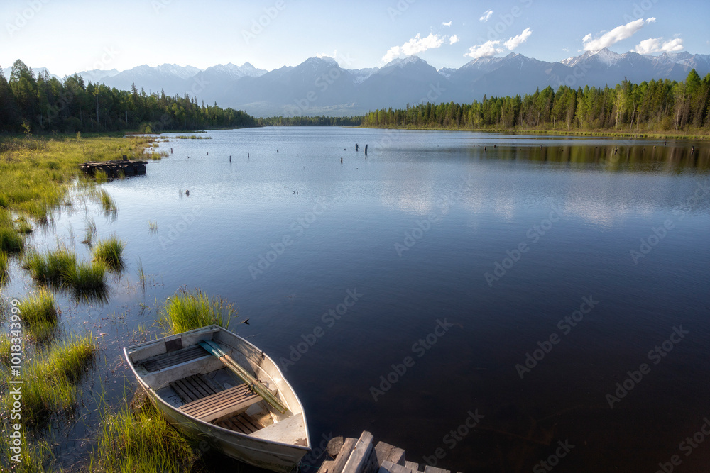Obraz premium Landscape with mountains, lake and old wooden boat