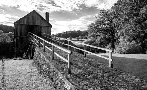 Historic blast furnace called “Luisenhütte“ in Balve-Wocklum, Sauerland (Germany) is a tourist attraction and example of early industrialization. Black and white vintage panorama in Hönne valley. photo