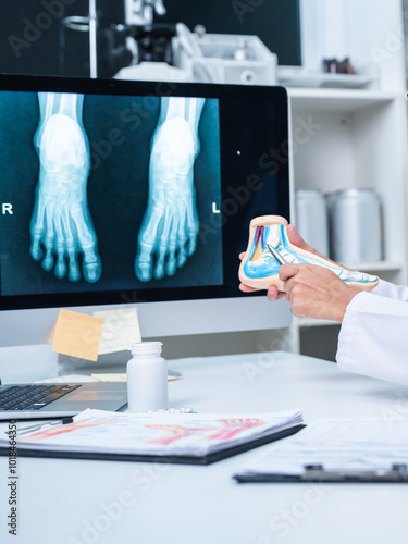 Professional Podiatrist doctor diagnose foot during medical examination of patient, doctor use foot model to explain the problem or injury of bone, structure of ankle, use x-ray to plan a surgery.