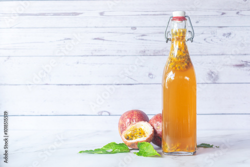 Kombucha second fermentation with passion fruit flavor in swing top bottles on white table background. photo