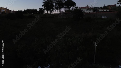 Aerial view of Patos and Prado beaches with houses above, after sunset. Toralla island and Vigo estuary are visible in the distance. View revealed behind Monteferro as camera ascends from Area Fofa. photo