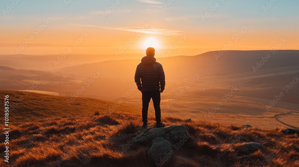 A silhouette of an individual on a hilltop gazes at the breathtaking sunset, with warm colors illuminating the landscape and creating a serene atmosphere during golden hour A silhouette of an individual on a hilltop gazes at the breathtaking sunset, with warm colors illuminating the landscape and creating a serene atmosphere during golden hour