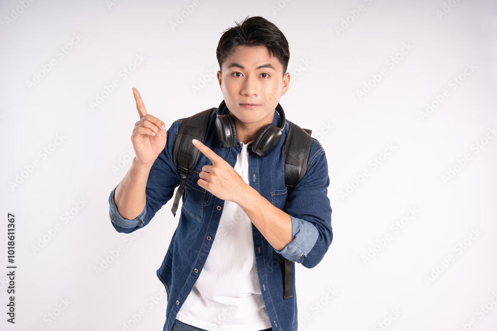 Portrait of Asian male student wearing headphones and schoolbag posing on white background Portrait of Asian male student wearing headphones and schoolbag posing on white background