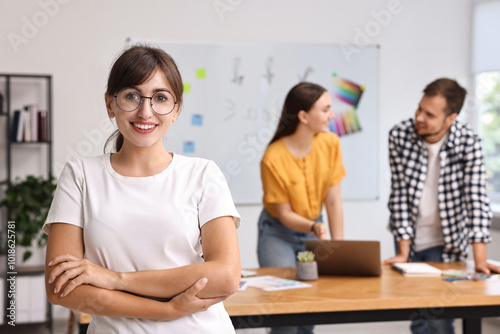 Happy young designer with glasses in office