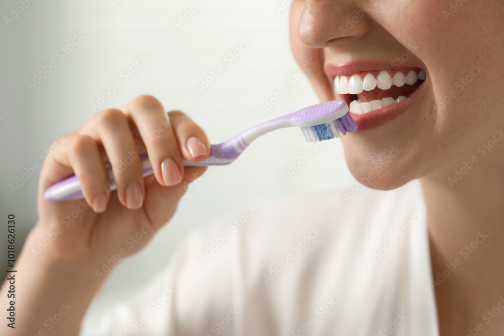 Woman brushing her teeth in bathroom, closeup Woman brushing her teeth in bathroom, closeup