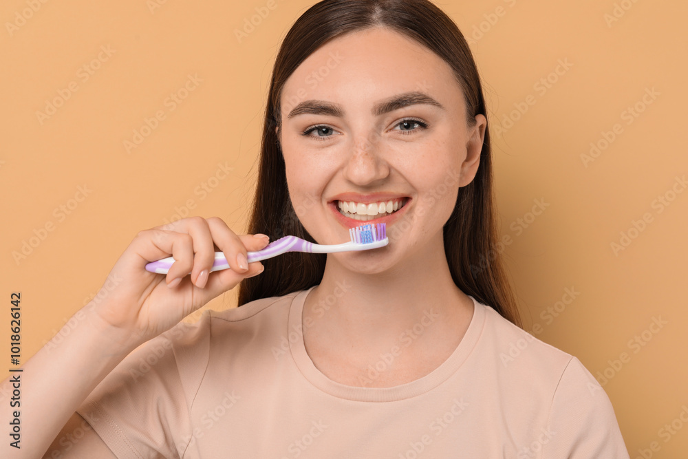 Beautiful woman brushing her teeth on beige background Beautiful woman brushing her teeth on beige background