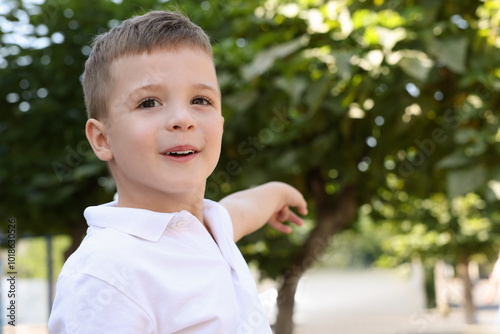 Portrait of little boy outdoors, space for text