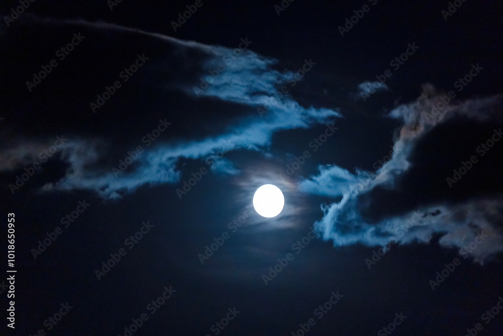 Obraz premium full moon in the night sky among the clouds.
