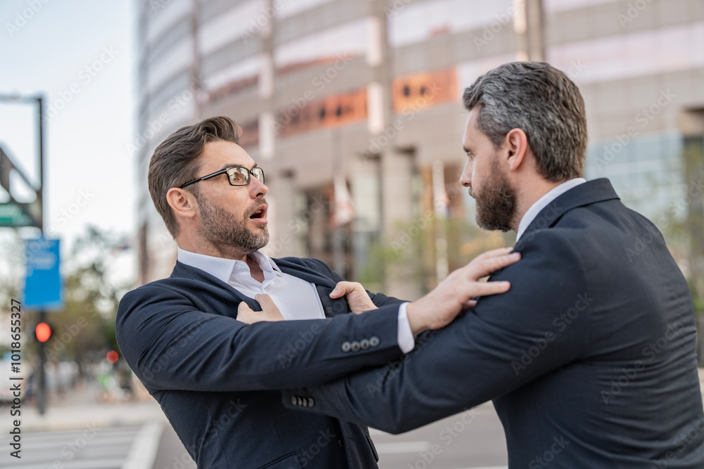 Two businessmen conflicting at fight outdoor. Businessmen having conflict in business. Conflict between boss and employee. Fight aggression. Angry businessmen threatening. Business conflict