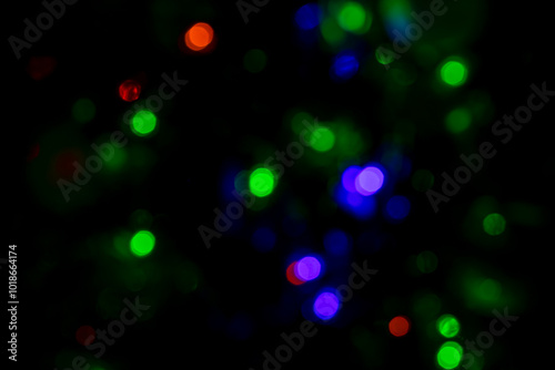 Multicolored Christmas lights on black background. Abstract colorful neon bokeh