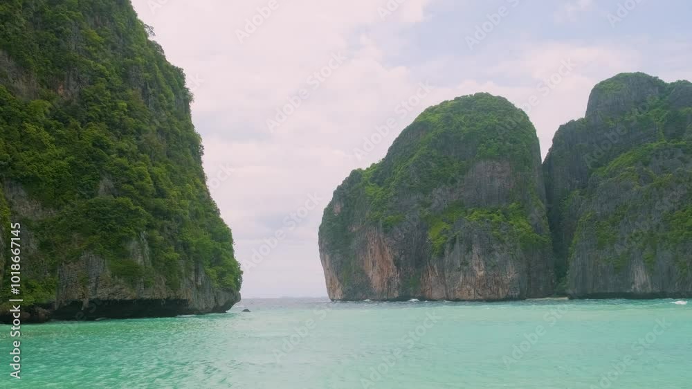 Maya Bay tropical sandy beach with turquoise water ocean on Phi Phi islands, Krabi, Thailand with nobody. Empty beach, surrounded by towering green cliffs under bright blue sky Maya Bay tropical sandy beach with turquoise water ocean on Phi Phi islands, Krabi, Thailand with nobody. Empty beach, surrounded by towering green cliffs under bright blue sky