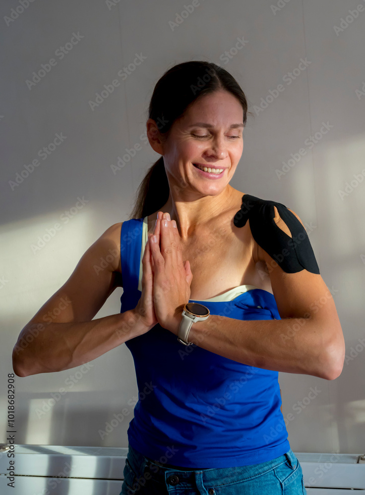 Woman with injured shoulder and Kinesiology Tape