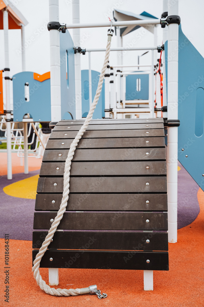 A sturdy rope is hanging down from a wooden structure that is part of ...