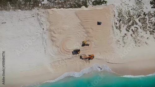Filming from the top of the loader and the truck moving the beach sand