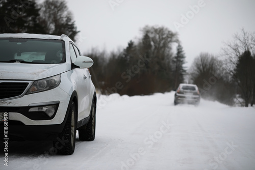 Snow-Covered Road with Two Cars in Winter Landscape**