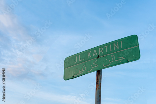 Close-up photo of the kartini street sign set against a clear blue sky photo