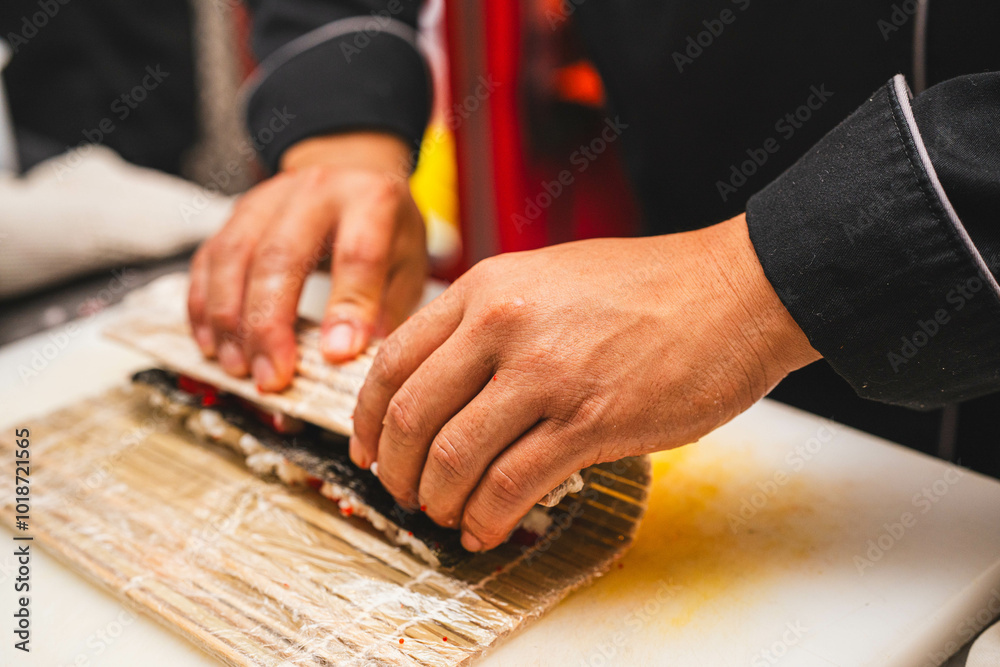 Close-up of a chef’s hands tightly rolling sushi using a bamboo mat. Perfect for sushi-making tutorials, culinary education, or food industry content. Close-up of a chef’s hands tightly rolling sushi using a bamboo mat. Perfect for sushi-making tutorials, culinary education, or food industry content.