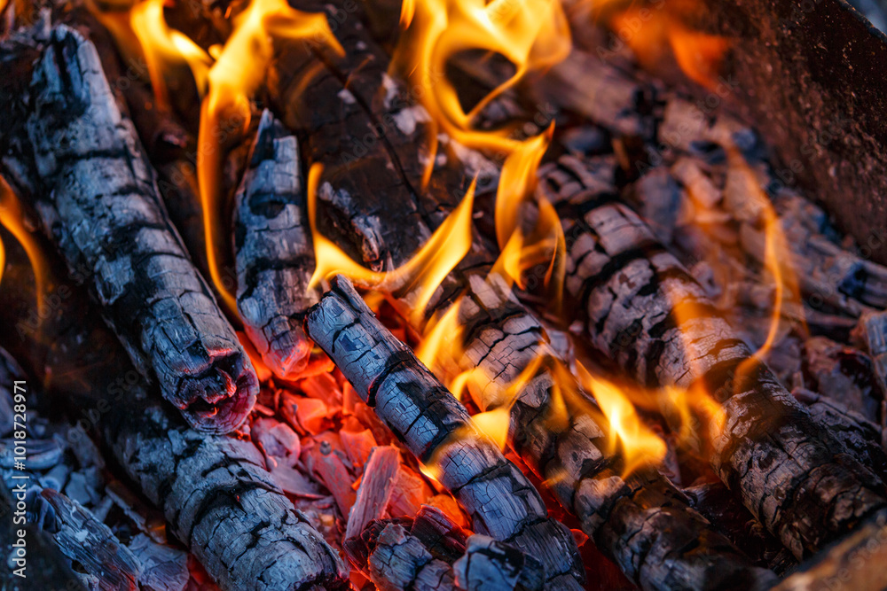 Red hot charcoal and a flame of fire.Close-up of fire, glowing charcoal and hot embers. The texture of flaming burning firewood. Red hot charcoal and a flame of fire.Close-up of fire, glowing charcoal and hot embers. The texture of flaming burning firewood.