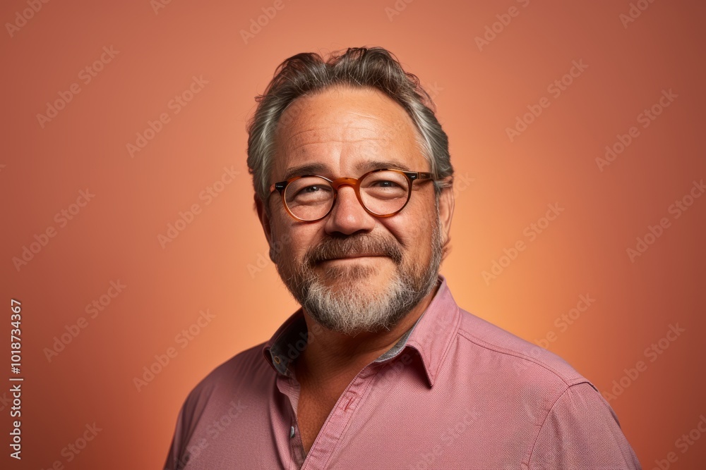 Portrait of a senior man with glasses on a brown background.
