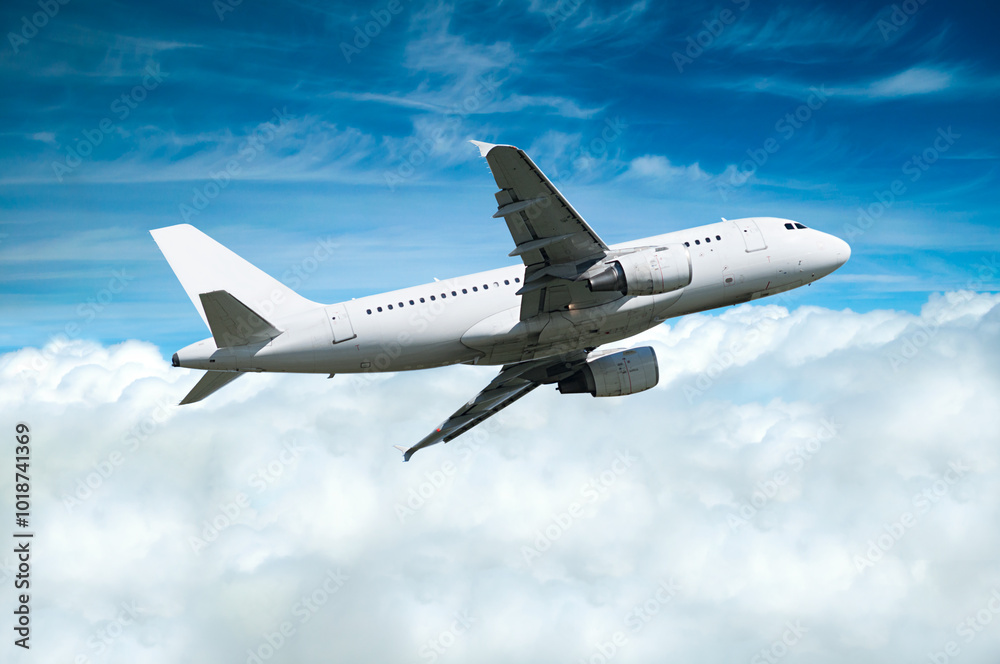Airplane in the flight, travel background with white airplane flying in the blue sky over the clouds. Flying airplane with blank livery Airplane in the flight, travel background with white airplane flying in the blue sky over the clouds. Flying airplane with blank livery
