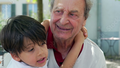 Young boy affectionately hugs his elderly grandfather outdoors, sharing a moment of closeness and love, tender expression. intergenerational connection and family bonds