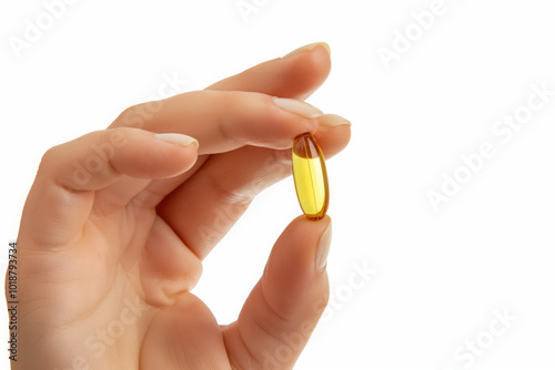 close-up of a woman's fingers, holding a big vitamin capsule on a white background