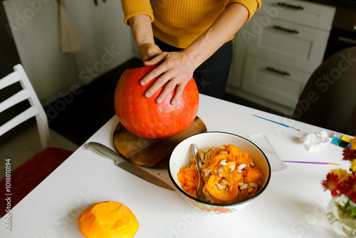 a man cuts a pumpkin for Halloween photo