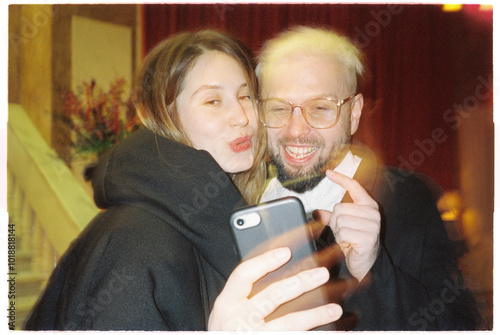 Spontaneous couple taking phone selfie 