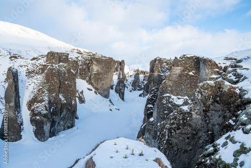 View of the famous Icelandic Fjadrargljufur, Fjaðrárgljúfur canyon during winter. Snowy canyon, frozen river in the canyon. Famous must-see touristic spot. Wonderful Icelandic landscape.  photo