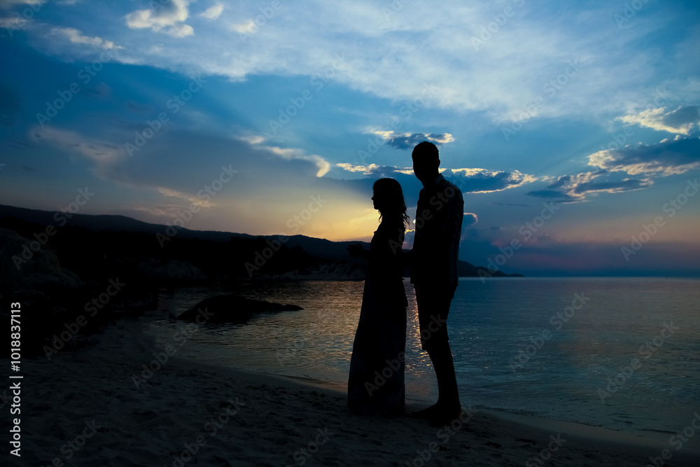 Fototapeta premium happy couple silhouette by the Greek sea on the shore background