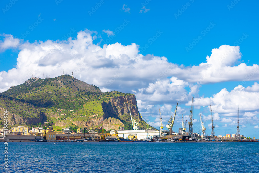 View of the Palermo port and Monte Pellegrino in Sicily Italy. Boats float on calm water with a majestic mountain rising in the background