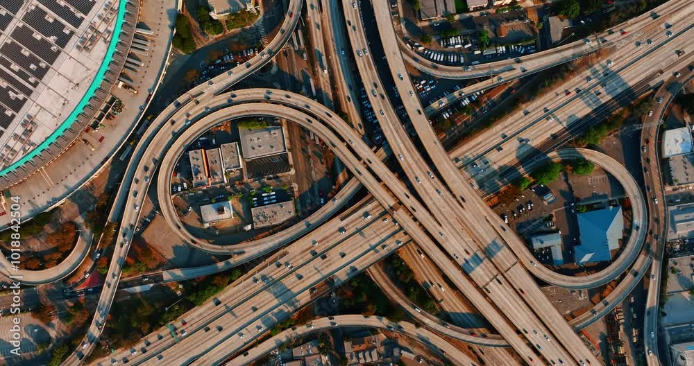 Los Angeles interchange with numerous cars moving by. Busy traffic on the highways of metropolis downtown. Top view. Los Angeles interchange with numerous cars moving by. Busy traffic on the highways of metropolis downtown. Top view.