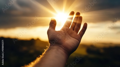 Hand reaching toward the sky with golden rays shining down symbolizing a connection with God and prayer 