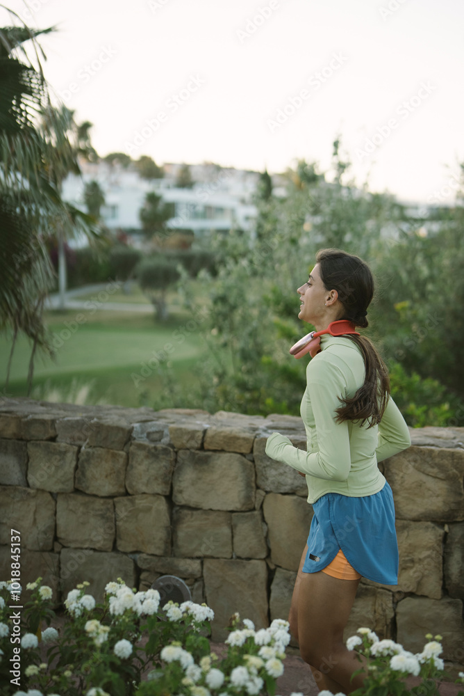 A woman is jogging in a beautifully scenic environment that enhances her experience A woman is jogging in a beautifully scenic environment that enhances her experience