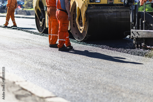 Ταπετσαρία Road construction workers operating heavy machinery on a sunny day while laying