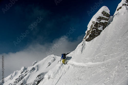 Skier rides in big rocky off-piste.