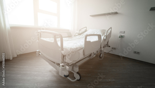Bild auf Leinwand An empty hospital bed in a clean, modern room with soft sunlight coming through the window