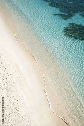 Tranquil beach setting with lounge chairs and umbrellas along a clear turquoi...