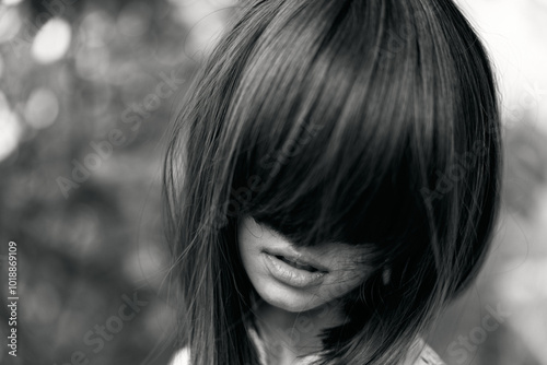 Tranquil woman with eyes closed and hair pulled back in black and white portrait