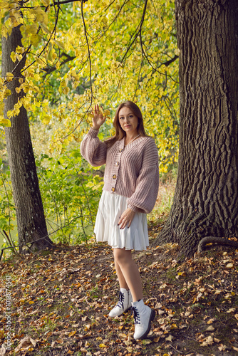 Obraz na płótnie portrait of a woman in a dress standing in a park in autumn w salonie