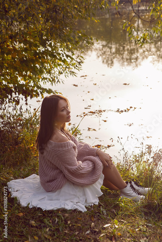 Obraz na płótnie portrait of a woman in a dress sit in a park in autumn. w salonie