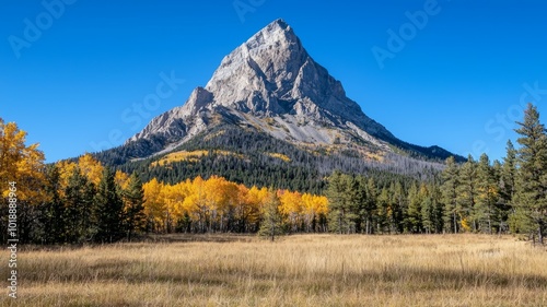 Majestic mountain peak surrounded by vibrant fall foliage and clear blue skies in a tranquil landscape during autumn in a national park