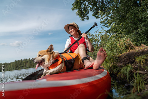 Woman and Corgi Enjoying Paddleboard Ride on Lake