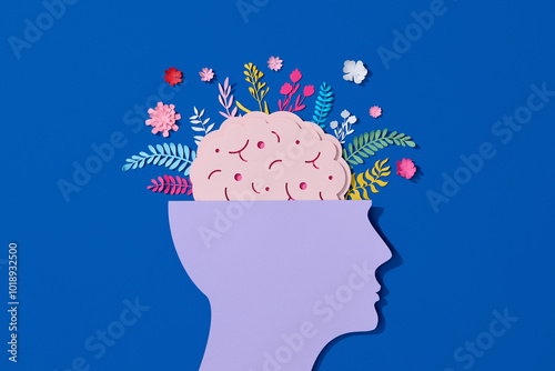 Paper cut displaying human head with flower-filled brain photo