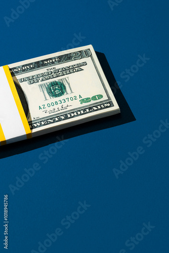Twenty dollars banknote bundle on navy background with copy space