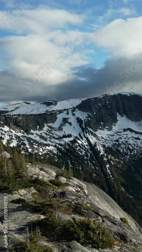 Wallpaper Mural Vertical video of snow capped mountain peaks and evergreen trees on a sunny day with white clouds in a blue sky. Perfect for nature, travel, and outdoor adventure videos. British Columbia, Canada. Torontodigital.ca