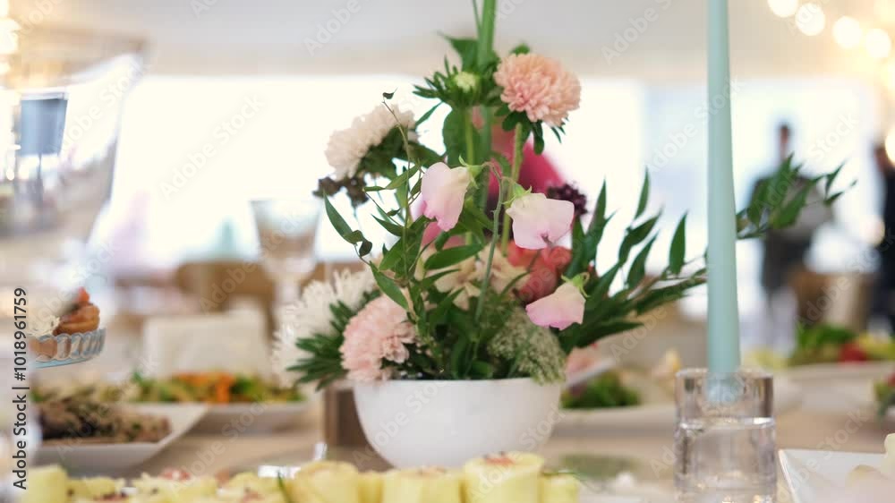 A beautifully set buffet table decorated with elegant flowers at a reception. A beautifully set buffet table decorated with elegant flowers at a reception.
